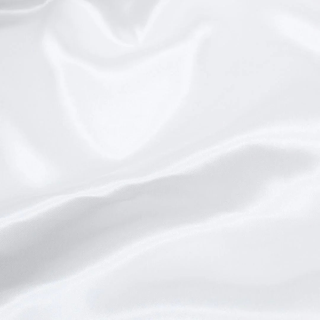 Nahaufnahme des glänzenden Satin-Stoffs in Weiß, ideal für Ballkleider und Dekorationen.