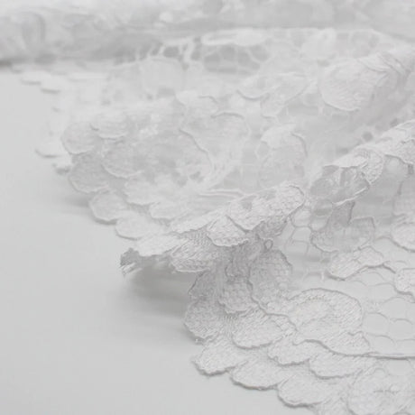 Eleganter schwarzer Spitzenstoff, drapiert und mit aufwendigem floralen Muster für Abendmode. Spitzenrand