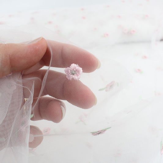 Detailaufnahme: rosa Blumenstickerei auf transparentem Tüllstoff, ideal für Kleider und Röcke