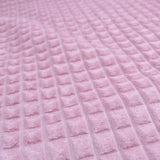 Dekostoff mit strukturierter Oberfläche und Quadrat-Prägung in Rosa