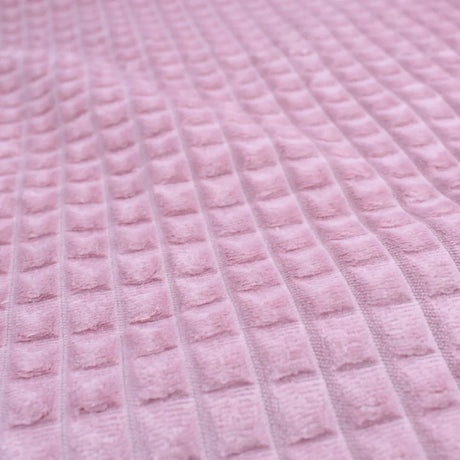 Dekostoff mit strukturierter Oberfläche und Quadrat-Prägung in Rosa