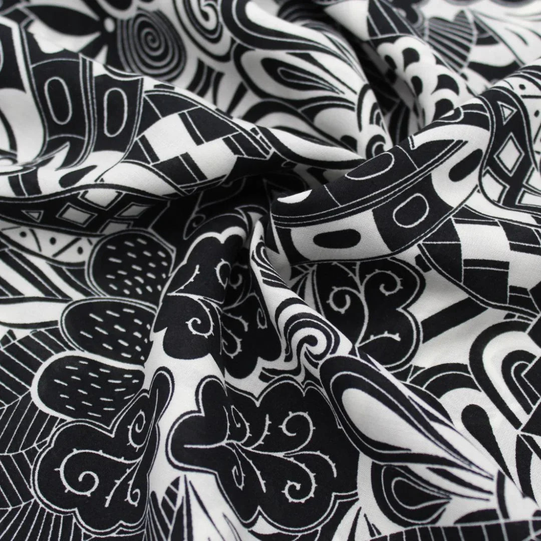 Viskose-Voile-Stoff in Schwarz-Weiß mit abstraktem Muster, perfekt für die Herstellung von Strandkleidern, Blusen und Röcken. Nahaufnahme