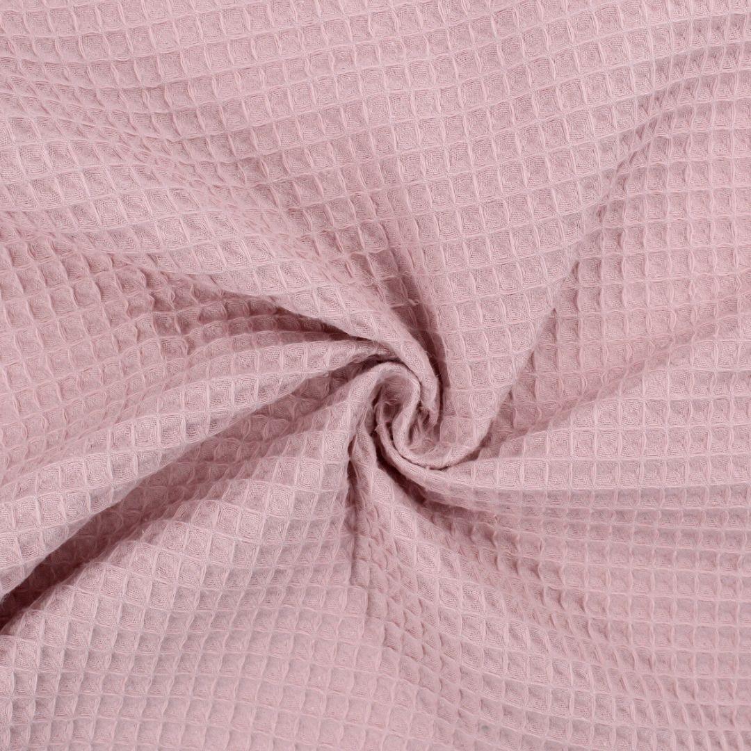 Fein gewebter Waffelstoff in zartem Rosa-Ton, ideal für Heimtextilien und Bekleidung.