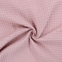Fein gewebter Waffelstoff in zartem Rosa-Ton, ideal für Heimtextilien und Bekleidung.