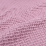Detailansicht eines hochwertigen Waffelpique-Stoffs in Rosa mit dreidimensionaler Wabenstruktur.