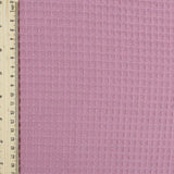 Fein gewebter Waffelstoff in zartem Rosa -Ton, ideal für Heimtextilien und Bekleidung.