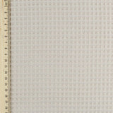 Fein gewebter Waffelstoff in zartem Beige-Ton, ideal für Heimtextilien und Bekleidung. Lineal