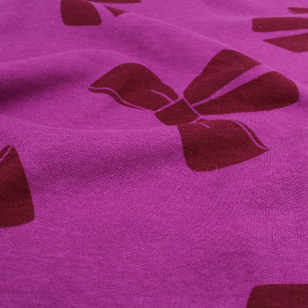 Lila Sweatstoff mit violetten Schleifen – weiche Meterware für Pullover